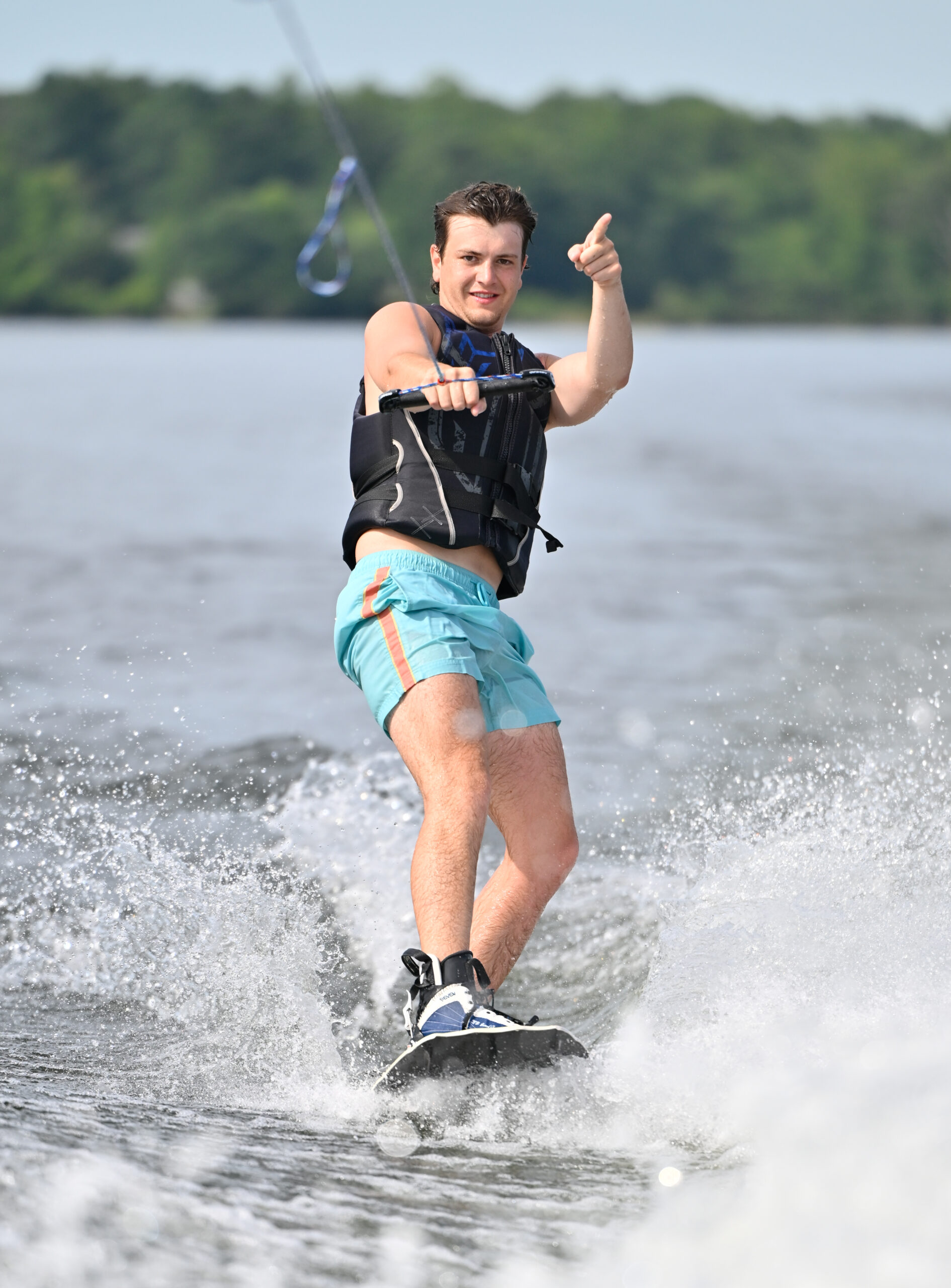 Nate wakeboarding pointing up in the air and smiling